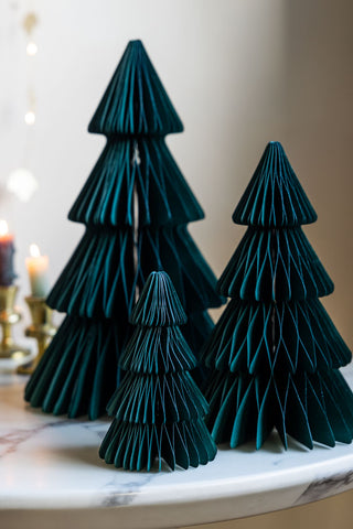 A lifestyle mage of the Set Of 3 Dark Green Honeycomb Christmas Trees with candles and fairy lights in the background 