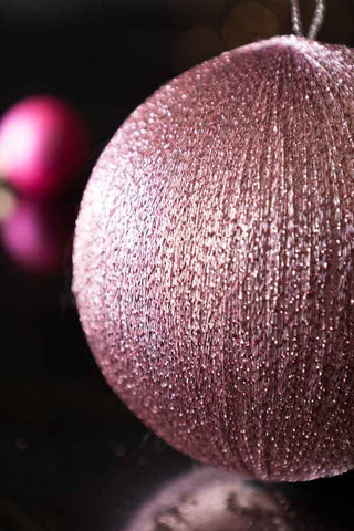 Detail shot of The Pink Metallic Spun Thread Christmas Bauble Decoration with a bauble in the background.