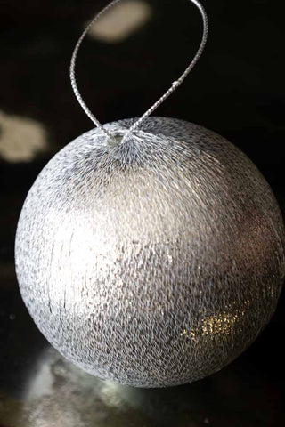 The Silver Metallic Spun Thread Christmas Bauble Decoration styled on a dark surface.