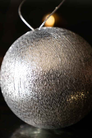 Close-up of the Silver Metallic Spun Thread Christmas Bauble Decoration styled on a dark surface.