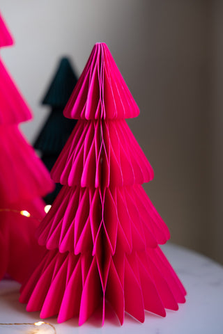 A detail of the medium tree in the Set Of 3 Neon Pink Paper Trees with fairy lights around it