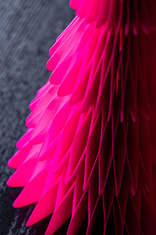 Detail shot of one of the Set Of 3 Neon Pink Paper Trees, displayed on a dark wooden surface.