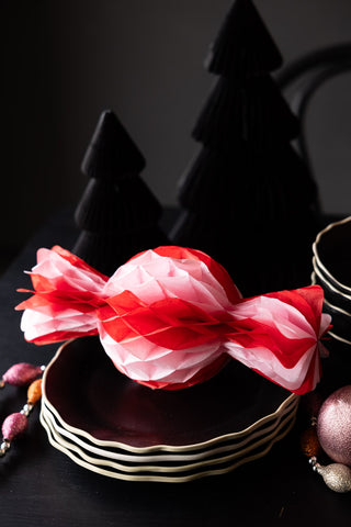 One of the Set Of 3 Pink & Red Honeycomb Sweets displayed on a stack of black plates as part of a Christmas tablescape.