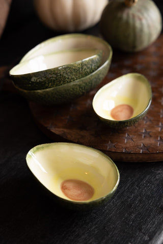 A Lifestyle image of the Set Of 4 Avocado Nesting Bowls styled on a dark worktop and star serving board