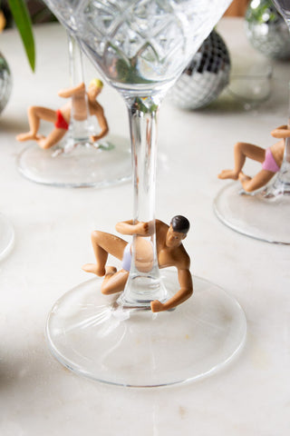 Three of the Set Of 4 Hunk Wine Glass Charms displayed on the base of some cocktail glasses.