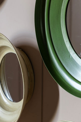 Close-up of two of the Set Of 5 Metal Frame Mirrors in Green & Natural displayed on a neutral wall.