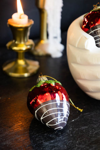 Detail image of a single strawberry decoration on a table dipped in chocolate.