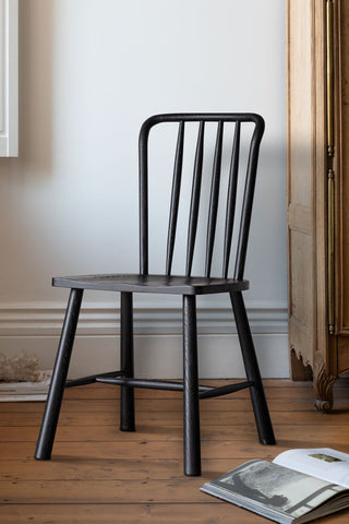 One of the Set of 2 Classic Wooden Frame Dining Chairs styled with some books and a piece of furniture in the background.