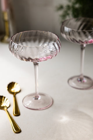 The Set of 2 Scalloped Coupe Cocktail Glasses styled together with some gold spoons.