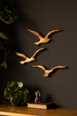 The Set of 3 Birds Wall Ornament styled on a black wall above a sideboard, with plants, a book and a candle.