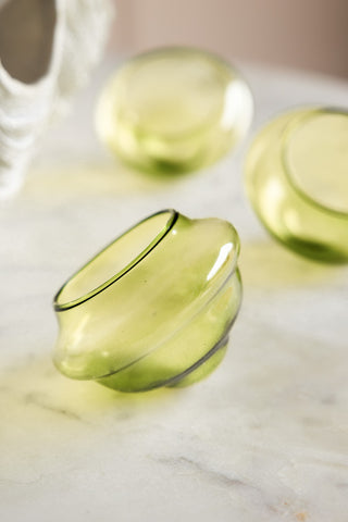 The Set Of 3 Pale Green Glass Tea Light Holders displayed together on a marble table.