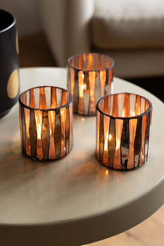 The Set of 3 Metallic Mosaic Effect Glass Tealight Holders on a table, styled with lit tealights inside.