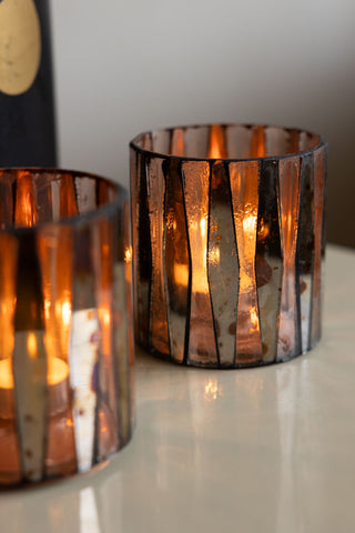 Close-up of two of the Set of 3 Metallic Mosaic Effect Glass Tealight Holders styled on a white surface with lit tealights inside.