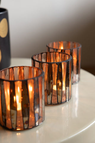 The Set of 3 Metallic Mosaic Effect Glass Tealight Holders arranged in a row on a table, styled with lit tealights inside.