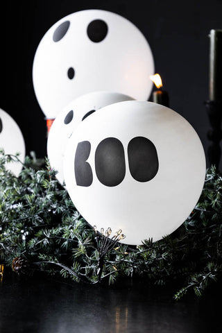 One of the Set of 5 Halloween Balloons styled on some greenery, with other balloons in the background.