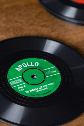 Close-up of two of the Set of 6 Vinyl Style Coasters displayed on a wooden surface.