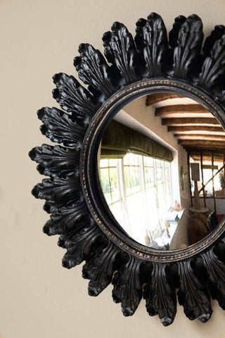 Close-up of one of the Set of 9 Ornate Antique Black Framed Mirrors styled on a light-coloured wall.