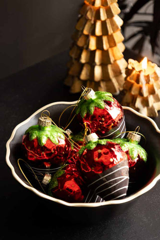 Close up image of the red strawberry decorations in a bowl.