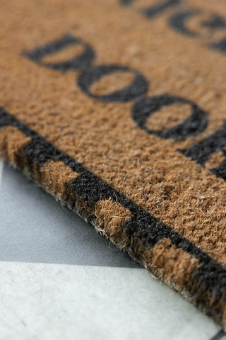 Detail shot of the edge of the Shut The Fucking Door Doormat.