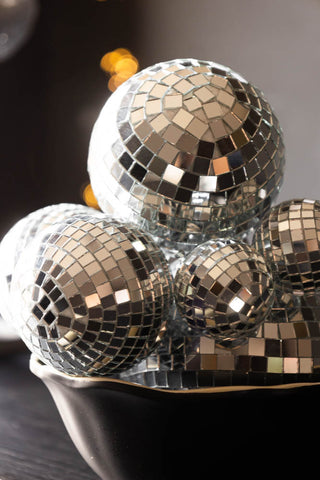 Close-up of the Silver Disco Ball Cluster Decoration displayed in a bowl on a wooden table.