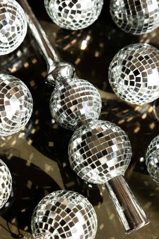 A close up of the Silver Disco Ball Tree Topper set with sunlight catching the mirrors