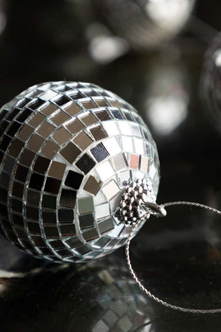 Close-up of a silver disco ball Christmas tree decoration.