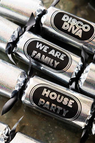 Set of six christmas crackers laid out in a formation.