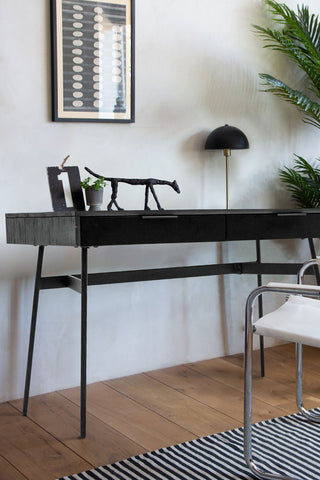 The Sleek Black Desk With Two Drawers styled with a chair, rug, lamp, plant and various decorative accessories.