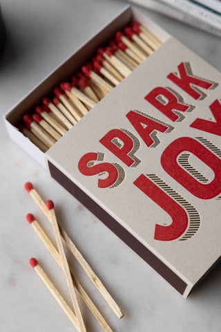 The Spark Joy Luxury Matches on a white surface, open with some of the matches out of the box.