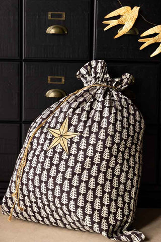 The Star Printed Christmas Sack in front of some black drawers, styled with a bird garland.