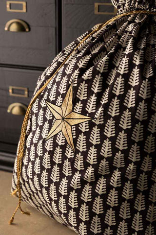 Close-up of the star on the Star Printed Christmas Sack, styled in front of some black wooden drawers.