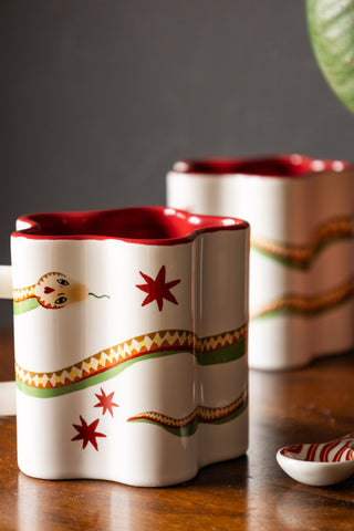 Detail shot of the Star Shaped Mug with Snake Print Detail next to a spoon, with another mug in the background.