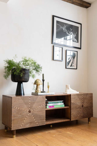 The Starburst TV Unit seen from a side angle, styled with a plant and various accessories.