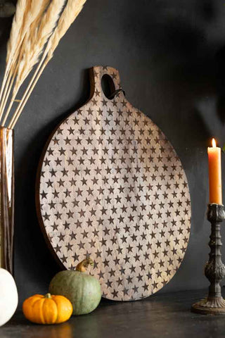 Large wooden round serving board on a dark background