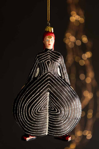 The Stripe Bowie Inspired Christmas Tree Decoration hanging in front a dark background with fairy lights.