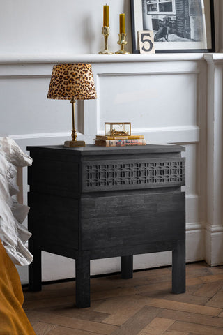 The Stylish Mango Wood 2-Drawer Bedside Table styled next to a bed with a lamp, some books and a jewellery box on.