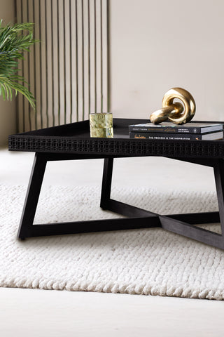 Beautiful black coffee table in a large living room styled with ornaments.