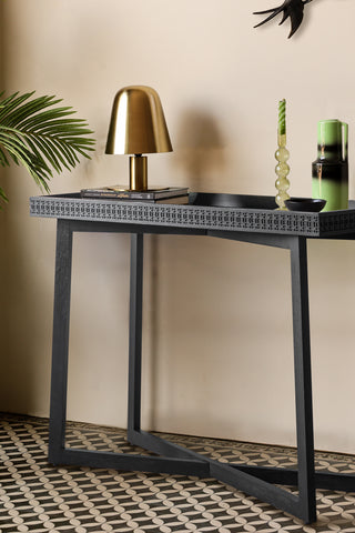 The Stylish Mango Wood Console Table styled with various accessories on, next to a plant.