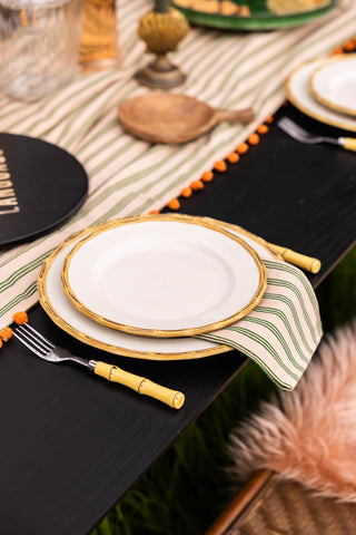 Two plates from the 12 Piece White Bamboo Dinner Set styled on a tablescape on a black wooden table.