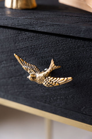 The Swallow Bird Knob - Gold displayed on a black drawer.
