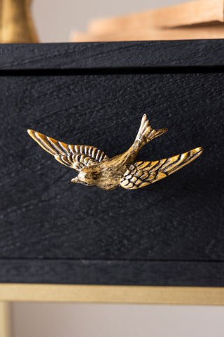 The Swallow Bird Knob - Gold shown on a drawer.