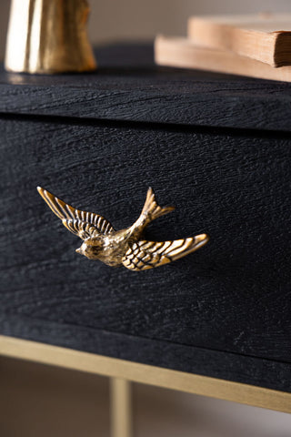 The Swallow Bird Knob - Gold shown fixed onto a drawer of a piece of furniture.