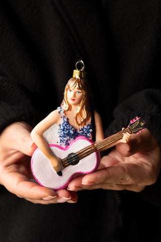 The Taylor Inspired Christmas Tree Decoration being held in a model's hands.