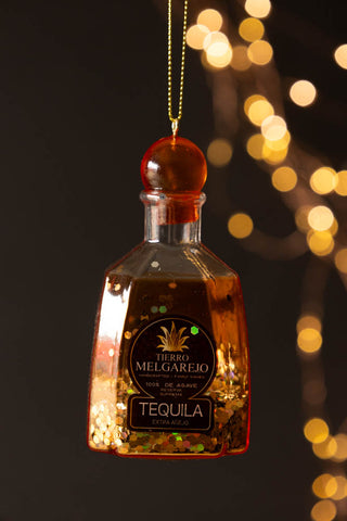 The Tequila Christmas Tree Decoration styled hanging in front of a dark background with fairy lights.