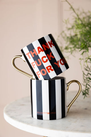 Two of the Thank Fuck For You Stripe Mugs on a marble table, one on top of the other.