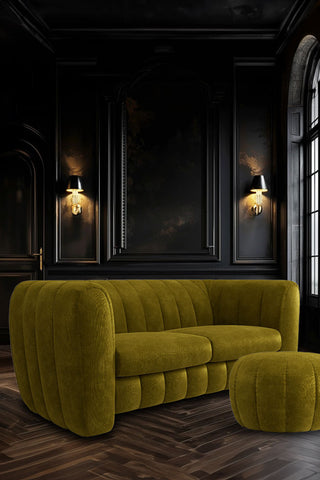 The Bowie Large Sofa In Luxe Kneedlecord Velvet Vintage Green styled in a dark panelled living room with a large window.