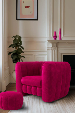 The Bowie Love Seat In Luxe Needlecord Velvet Harry's Pink styled in front of a fireplace with a matching footstool, with a plant, some pink vases and an art print also in shot.