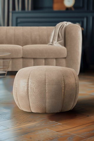 The Bowie Stool In Luxe Needlecord Velvet Natural Whisper on a wooden floor in a living room, with the matching sofa in the background.