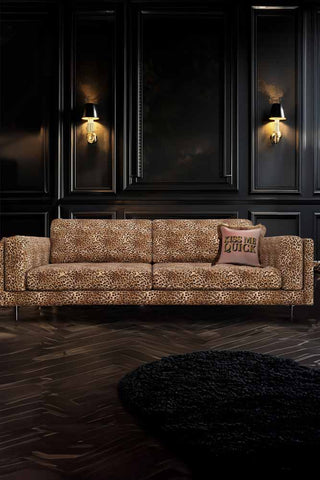 The Grace Large Sofa In Leopard Love Velvet Natural styled in a dark living room, seen from the front.