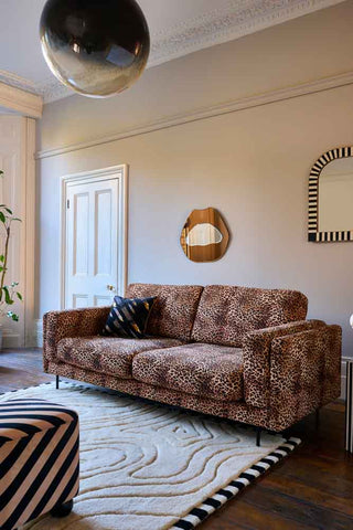 The Grace Medium Sofa In Leopard Love Velvet Natural styled in a living room with cushion on.